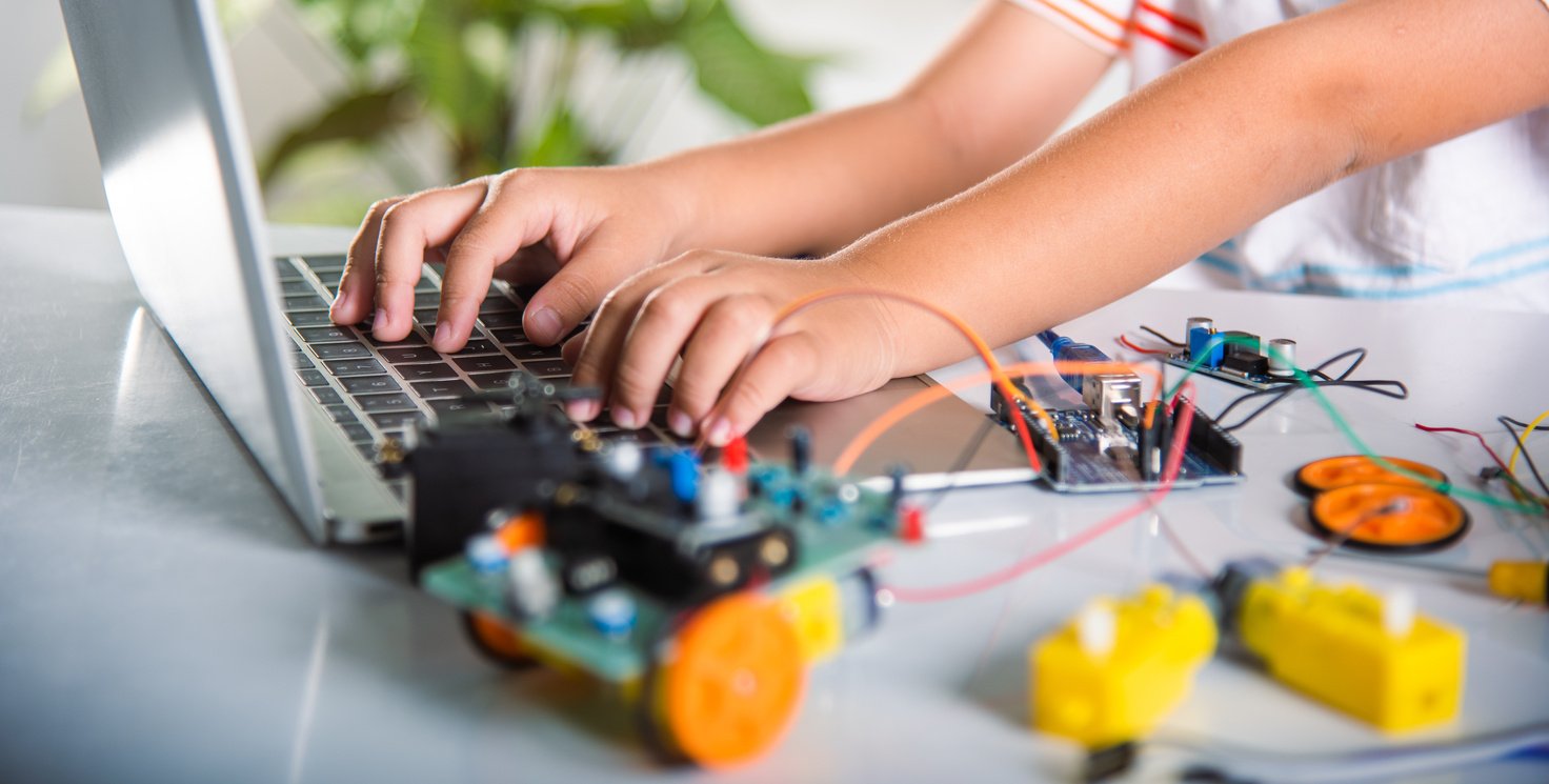 Asian kid boy learns coding and programming with laptop for